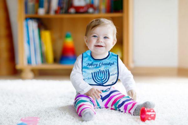 Adorable baby girl playing with educational toys in nursery Bavoir Happy hanouka